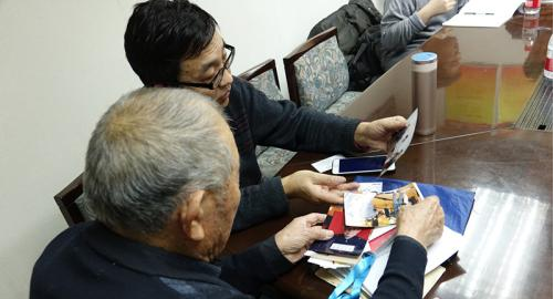 閆玉成向童增展示自己近年來收集的與索賠相關的照片、材料。 <a target='_blank'  ></table>中新網</a>記者 張尼 攝