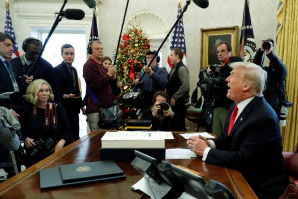 2017年12月22日，在美國華盛頓白宮，美國總統特朗普（右）簽署減稅法案后對媒體講話。（新華/路透）